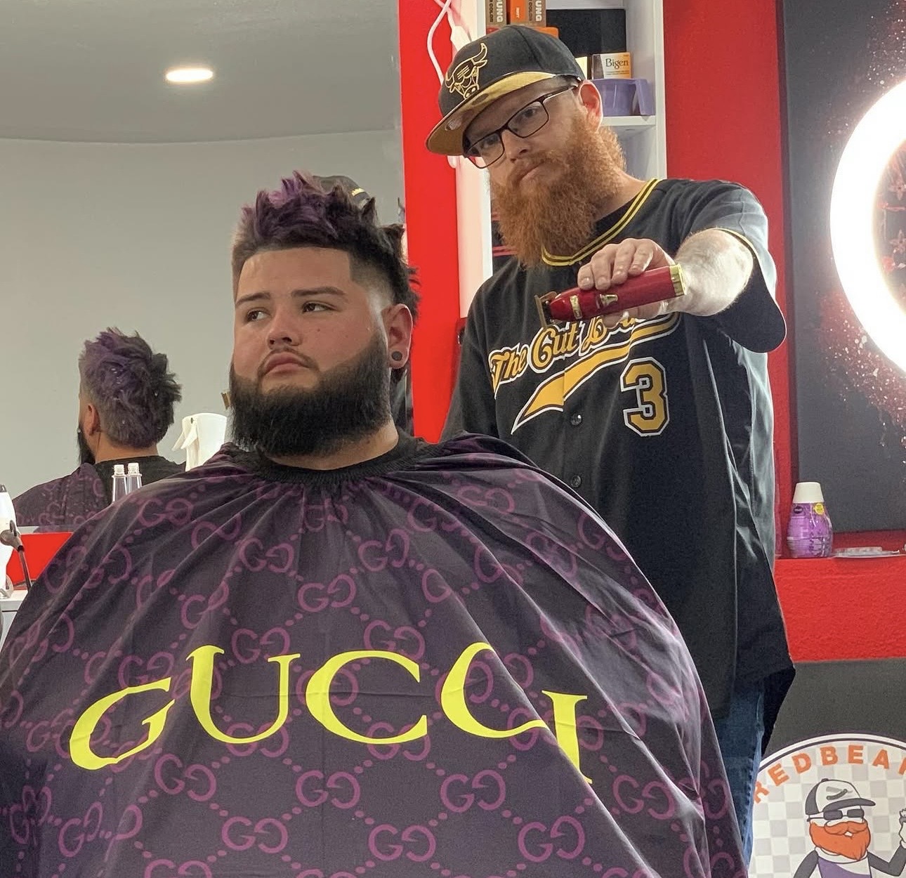Redbeard standing behind a client with clippers in hand at Mad Hare Barber